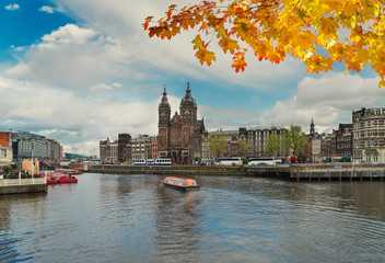 Amsterdam skyline with Church of St Nicholas over old town canal, Amsterdam, Holland at autumn day