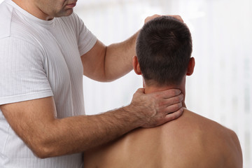 Fototapeta premium Chiropractic back adjustment. Muscular Man suffering from back and neck pain.