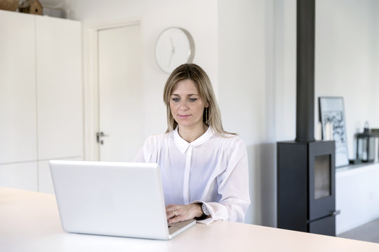 Businesswoman working on computer in black and white living space