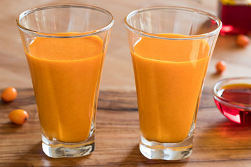 Two glasses of sea buckthorn juice, with sea buckthorn oil and berries