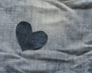 background of alone denim heart lies in rumpled blue fabric