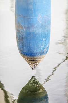 buoy,old blue boat bumper,reflection in water