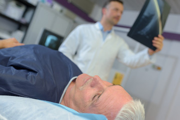 Obraz premium male doctor discussing x-ray with senior man in hospital
