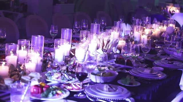 Decorative candles on the dining table, glasses and Christmas candles on the table, white wax candleswith glass candlestick, Candle with Glass Candlestick, restaurant, interior, close-up