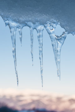 Hanging icicles with mountain landscape in the background