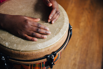 Hands of a young black girl on a djembe drum