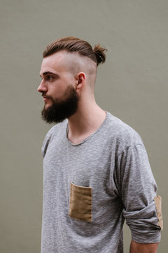 Portrait of a handsome bearded man with samurai bun hairstyle