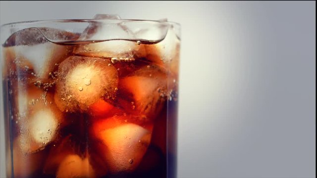 Cola with ice cubes background. Cola with Ice and bubbles in glass. Soda closeup. Food background. Stock full HD video footage 4K