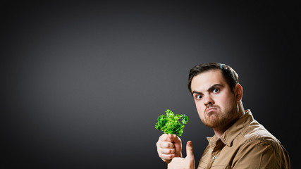 Man holding parsley and raises his thumb up