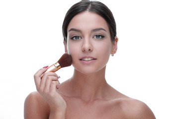 Obraz na płótnie Canvas Close-up of a beautiful woman with a make-up brush