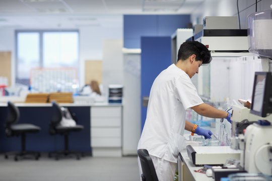 Female lab technician washing instruments