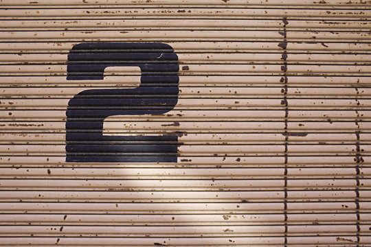 the number 2 painted on a graphic pink wall / door
