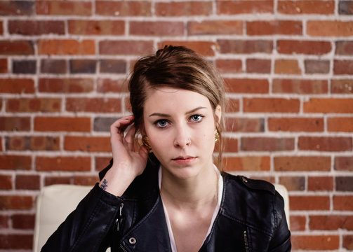 Portrait of young female in front of brick wall