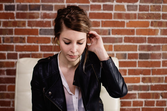Portrait of young female in front of brick wall
