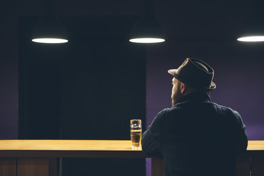 Young man with hat and beer in the bar