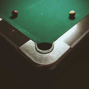 Corner of a pool table with two pool balls