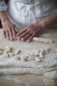 Making homemade pasta: woman shaping potato gnocchi