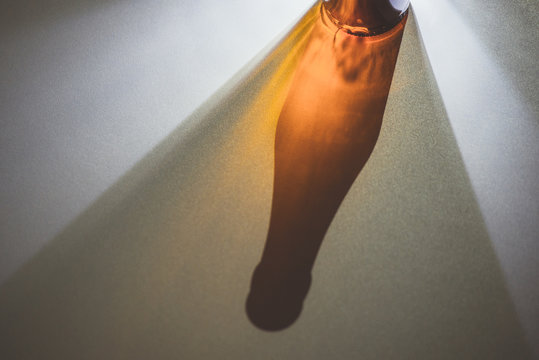 Projection of a bottle shadow on a white table