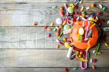 Halloween candies on wood table - background top view