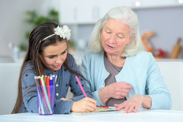 grandchild drawing at home with grandmother
