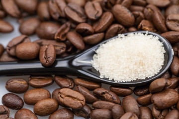 Coffee beans and small teaspoon with brown sugar