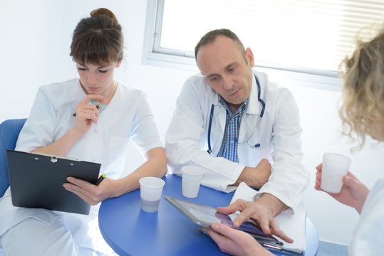 medical doctor team taking a coffee break using digital tablet