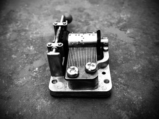 Black and white mechanical music box on a tile background