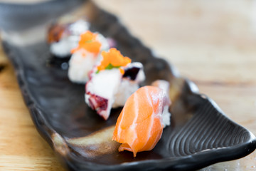 Japan raw salmon sushi and fresh mix sushi set in black plate - Japanese food set style at Japanese restaurant..