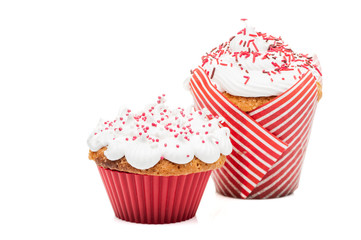 two cupcakes muffins with cream and red icing isolated at white background