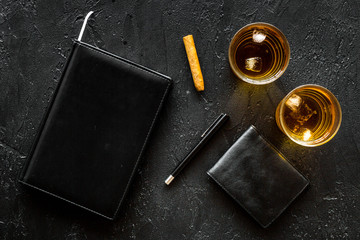 Man set. Whiskey with ice, cigar, wallet and notebook black bar background top view copyspace