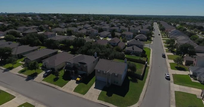 A daytime rising aerial establishing shot of a typical San Antonio, Texas residential neighborhood.  	