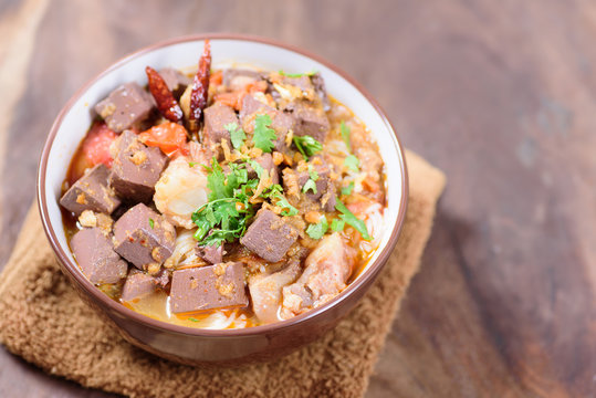 Northern Thai food (Kanom Jeen Nam Ngeaw) on wooden background,spicy rice noodles soup,rice vermicelli served with curry