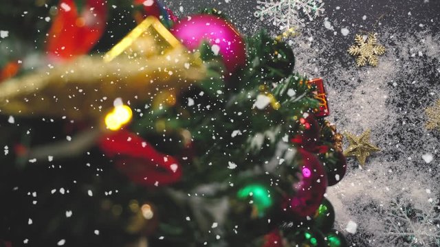 Greeting Season concept.Christmas tree and decorations with presents and ornaments on wood table from above with falling snow in 4k (UHD)