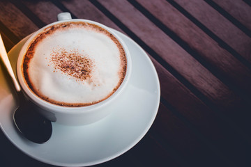 a cup of coffee on the brown wood table floor .