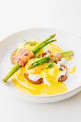 Eggs benedict with bacon twist asparagus