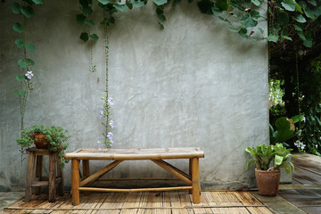 Bamboo chairs are placed next to the mortar wall. There are sawn trees around the walls and the building. Asian style gardening. copy space.