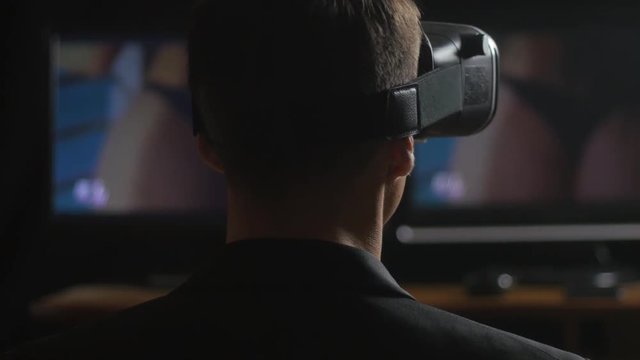 man watching erotic video using Virtual Reality headset.