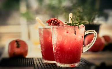 Pomegranate cocktail with rosemary sprig
