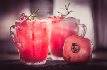 Pomegranate cocktail with rosemary sprig