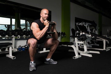 Fototapeta na wymiar Legs Exercise With Dumbbells In A Gym