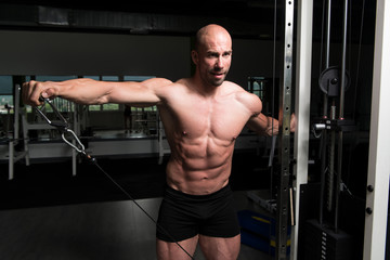 Fototapeta na wymiar Man Exercising Shoulders In The Gym
