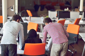 Multiracial contemporary business people working connected with technological devices like tablet and laptop