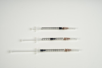 insulin and large syringe, white background.