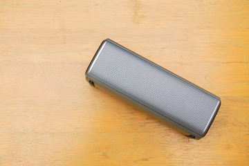 close up portable wireless speaker on wooden table to connect with smartphone for music listening