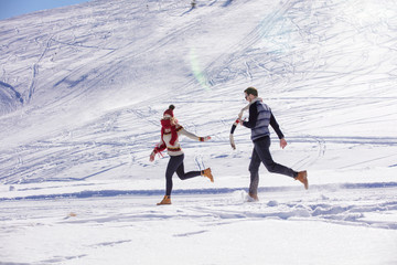 Carefree happy young couple having fun together in snow.