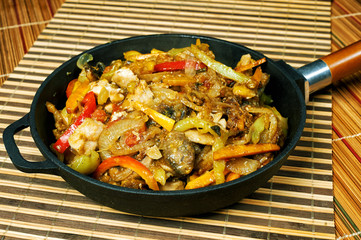 Stewed chicken with vegetables in cast iron cookware