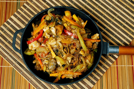 Stewed chicken with vegetables in cast iron cookware