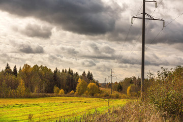 Colorful autumn landscape with field and poles of power lines. Evening. The sky with heavy clouds. Pictures, Wallpapers, calendar.