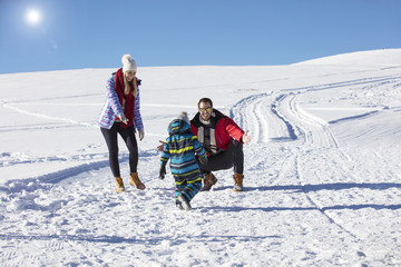 Attractive family having fun in a winter park on mountain