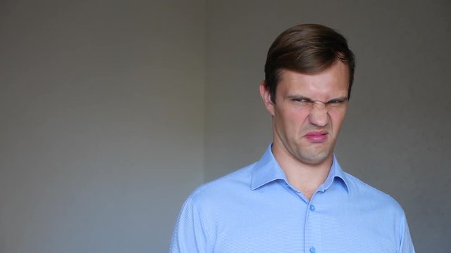 4k. Slow motion. Close up portrait of a young man. body language and gestures. he is disgusted.